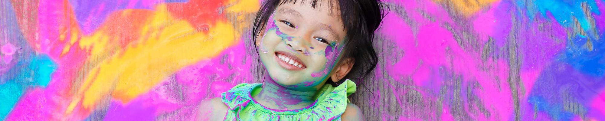Kid covered in paint and smiling